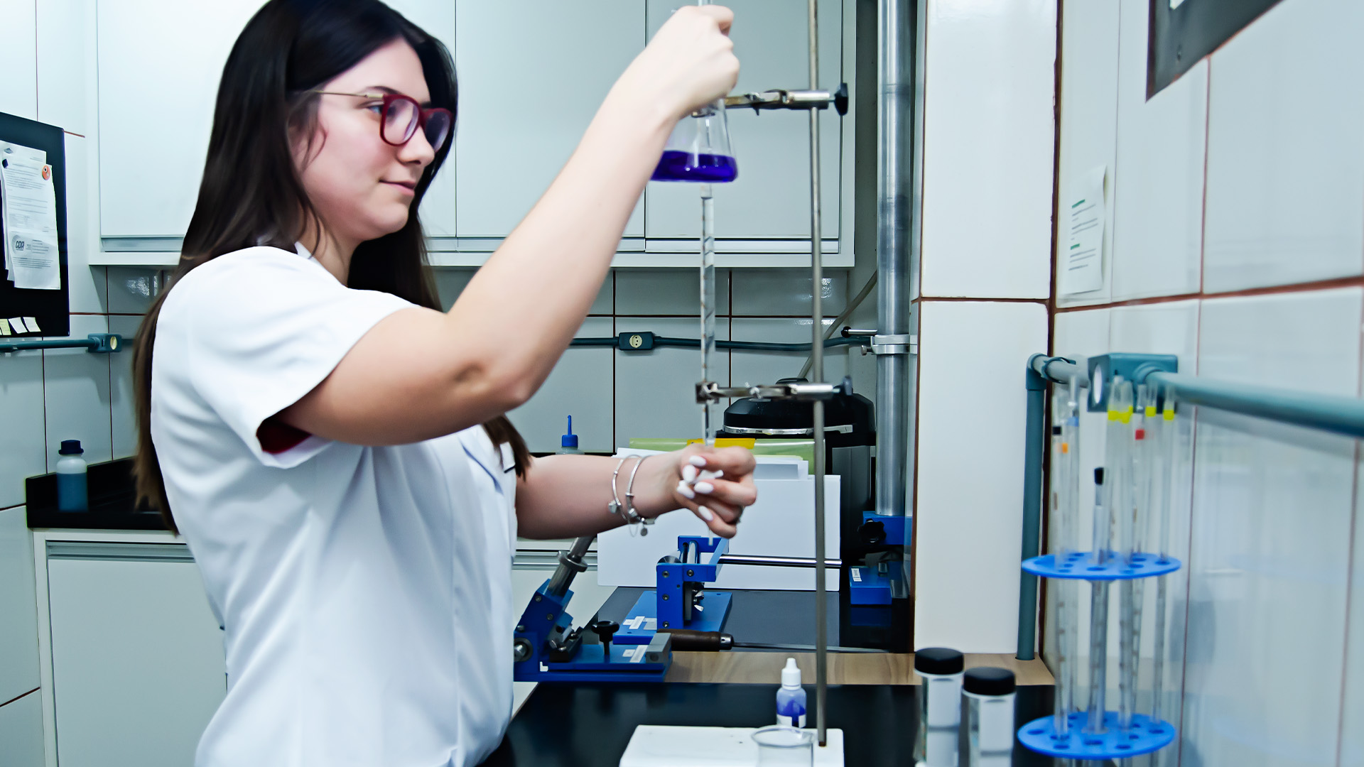 Profissional de laboratório realizando controles químicos do processo de pintura
