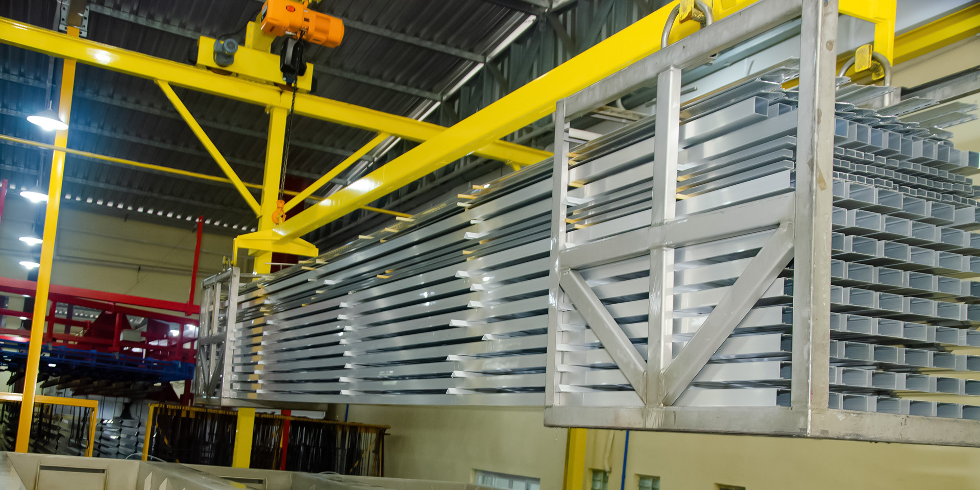 Linha de pintura com perfis de alumínio em processo de acabamento